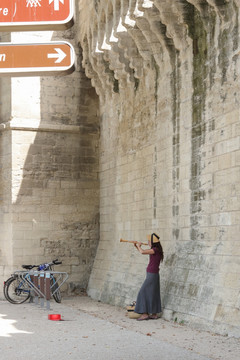 古城墙下吹奏乐器的女孩