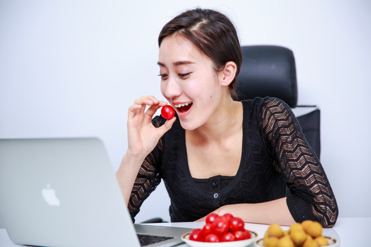 在办公室里吃番茄的女人