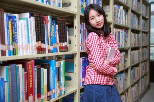 微笑的女学生抱着书本