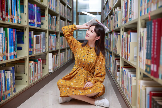 盘腿坐在图书馆地上的女学生