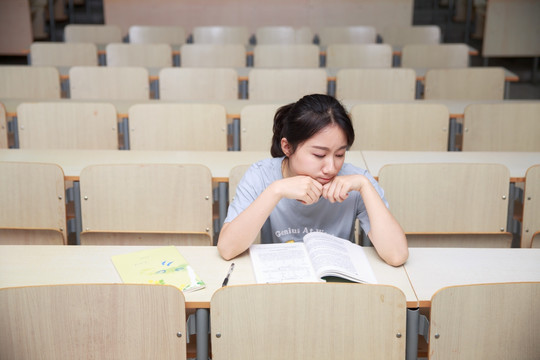 不开心的女学生在大学教室里看着别处