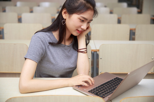 在大学教室里用电脑的女打大学生