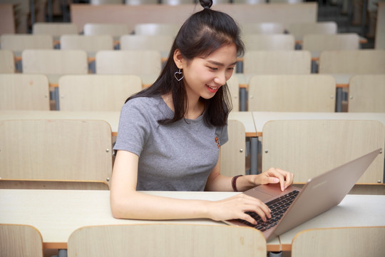 在大学教室里使用笔记本电脑的女学生