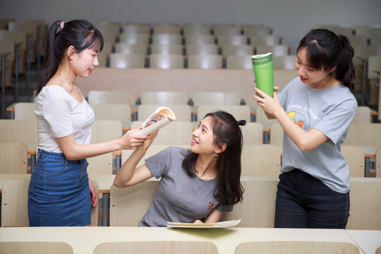 拿着书本打闹的女学生们