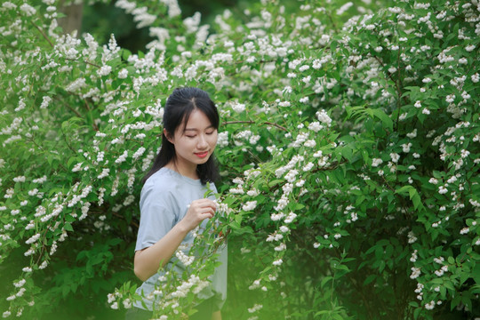 微笑着看着花朵的女学生