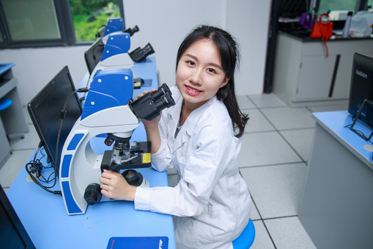 女学生使用显微镜做着实验