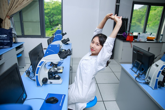 坐在实验室里伸懒腰的女学生