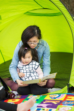 在户外野营读书的母女