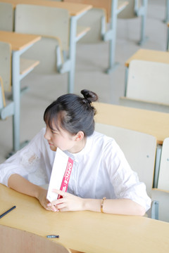 坐在教室里拿着课本的女大学生