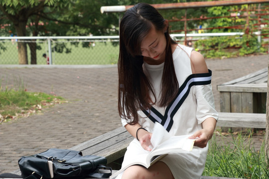 坐在休闲椅上学习的女大学生