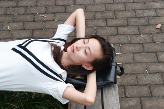女大学生躺在休闲椅上睡觉