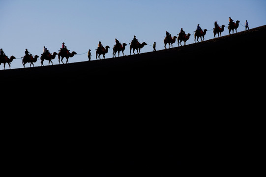 沙漠中骑骆驼的人群
