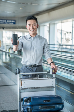 年轻商务男士在机场展示手机