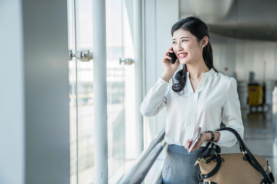 年轻商务女士在机场打电话