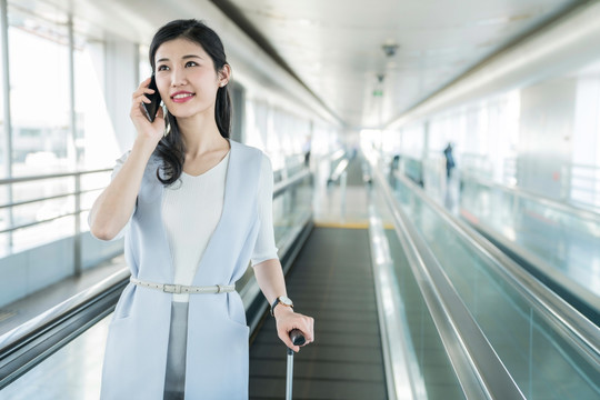 年轻商务女士在机场打电话