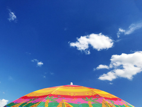 蓝天白云下彩色阳伞