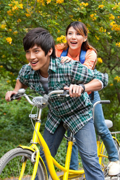 年轻大学生情侣在校园里骑车