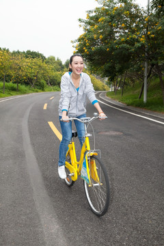 一个年轻女大学生在校园里骑车