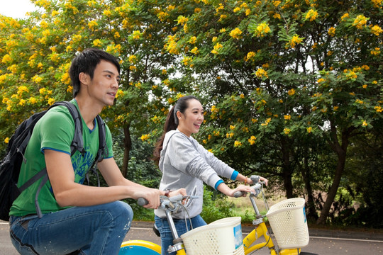 年轻大学生在校园里骑车