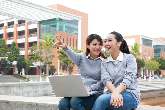 年轻大学生在校园里使用笔记本电脑