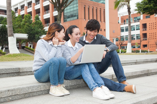 年轻大学生在校园里使用笔记本电脑