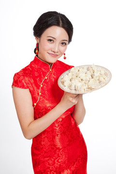 棚拍身穿中国传统服装的年轻女人端饺子