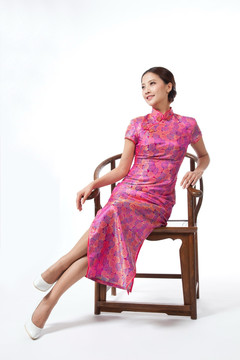 棚拍身穿中國傳統(tǒng)服裝的年輕女人坐中式椅