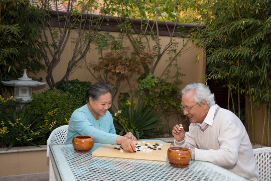 老夫妻在庭院里下棋