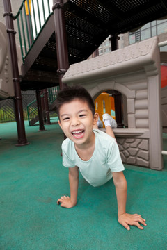 小男孩在幼儿园内玩滑梯
