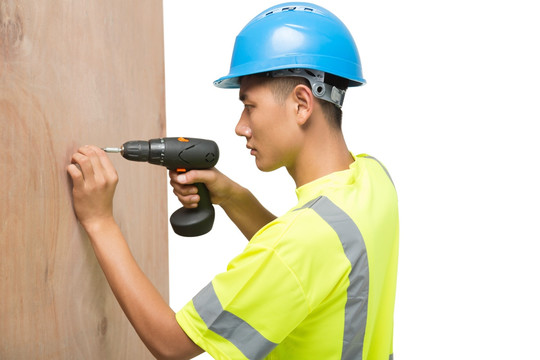 年轻的男建筑工人用电钻