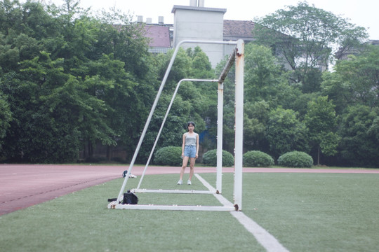 女学生站立在学校操场上