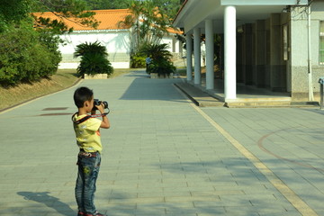 小孩子举起单反相机摄影
