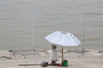 长江岸边撑伞钓鱼