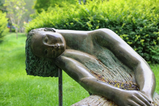 半躺下的少女铜雕像