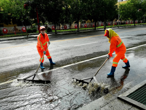 雨后环卫工人清扫积水