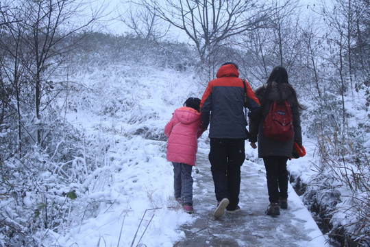 一家三口牵手在雪中散步