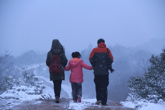 一家三口牵手雪中散步