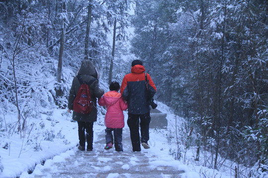 一家三口牵手雪中散步