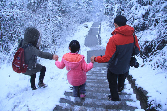 一家三口牵手雪中散步