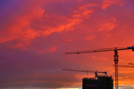 红色夕阳中的建筑工地塔吊