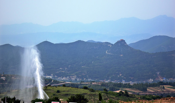 喷洒的水柱和远山风景图