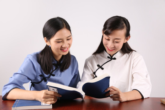 微笑的两名学生在一起看书