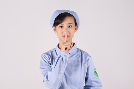 手指放在嘴唇上的年輕女護士