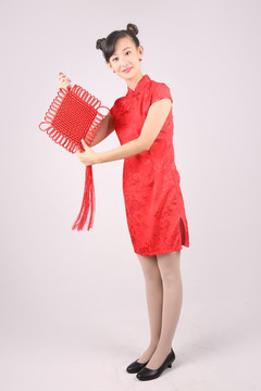 穿着红色旗袍的女人拿着中国结