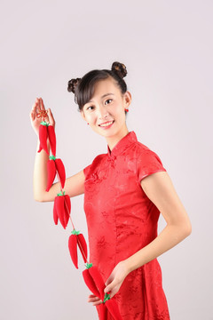 漂亮女人微笑著拿著紅辣椒掛飾