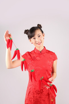 舉著紅辣椒掛飾的女人