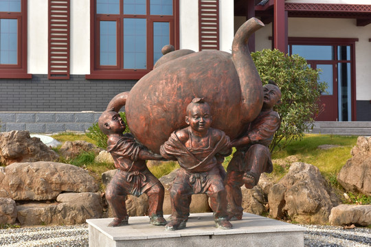 三个小孩背茶壶雕塑