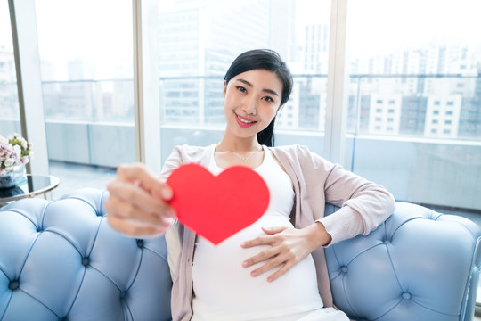 年輕孕婦坐在沙發(fā)上