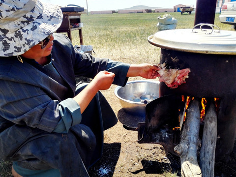 烤羊肉的蒙古族女人