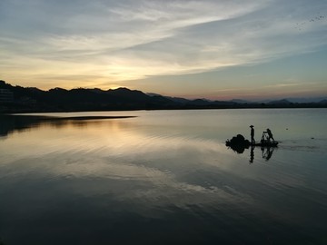 夕阳朦胧的海边渔船回岸